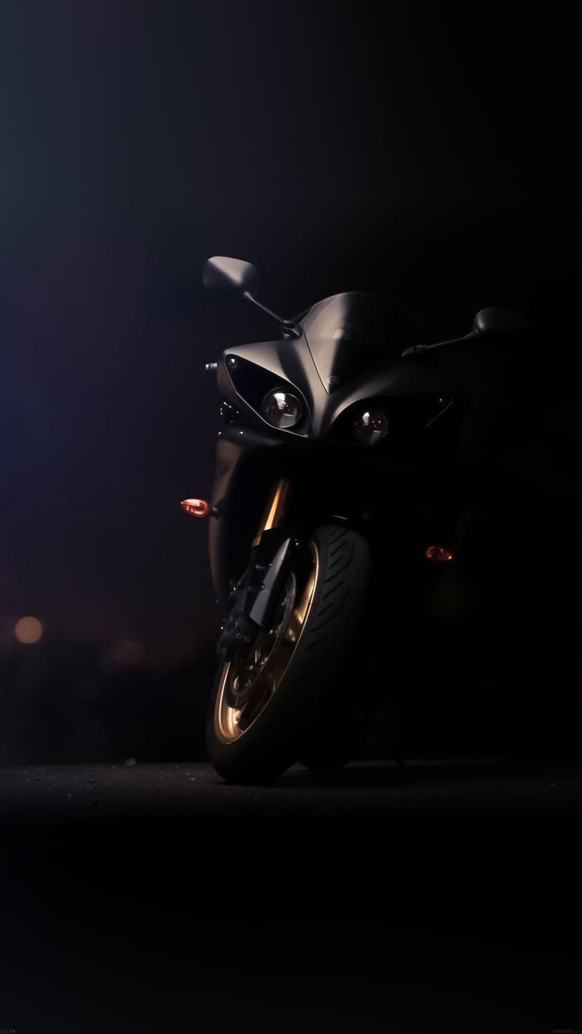Matte black sportbike with gold forks and rims emerging from shadows under dramatic low-key lighting.