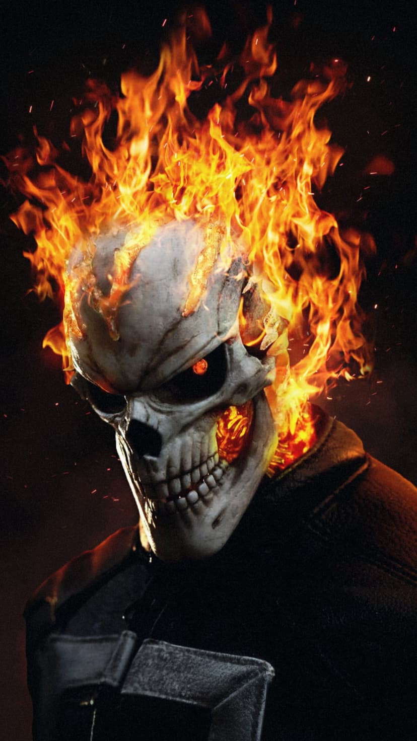 Ghost Rider skull engulfed in orange flames with glowing eyes wearing a dark leather jacket in a smoky scene.