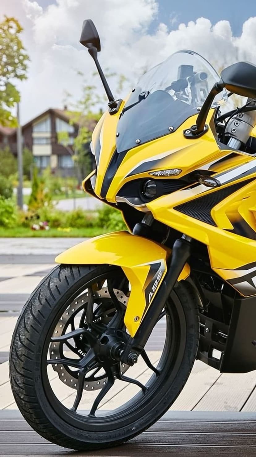 Yellow sportbike front wheel and aerodynamic fairing with a blurred suburban background during daylight.