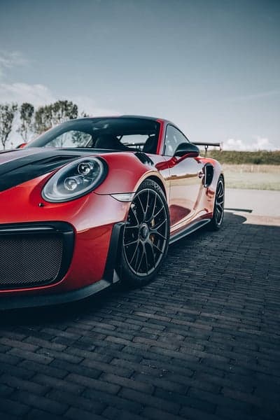 Red Porsche 911 GT2 RS parked on brick road