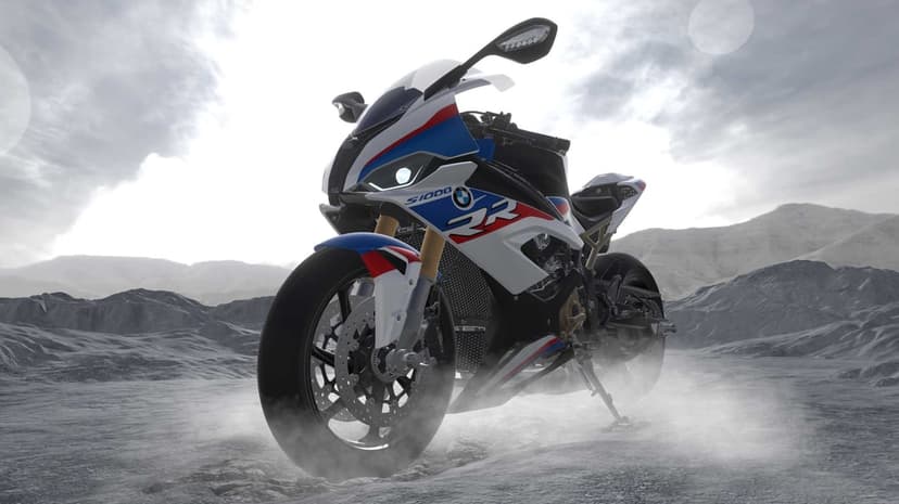 BMW S1000RR sportbike in white and blue livery parked on rocky terrain with mist and a bright sky.