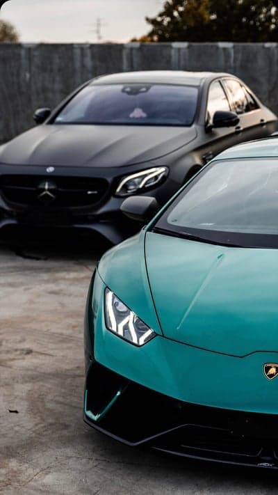 Luxury Cars: Teal Lamborghini and Black Mercedes Sedan