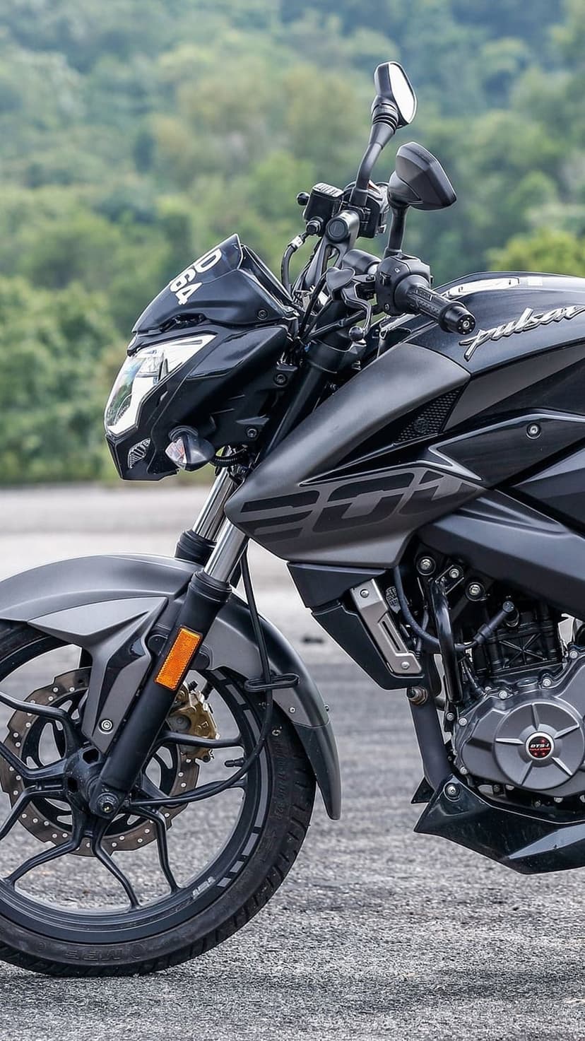 Bajaj Pulsar NS200 motorcycle in grey features a detailed front wheel, engine components, and sporty fuel tank.