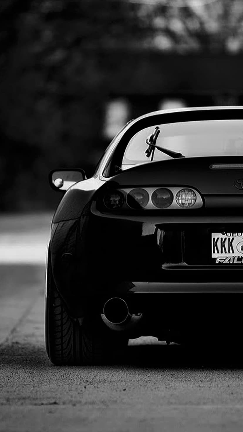 Toyota Supra rear bumper and iconic round taillights with a custom license plate in high-contrast monochrome.