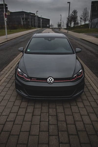 Dark Grey Volkswagen Golf GTI parked on brick road