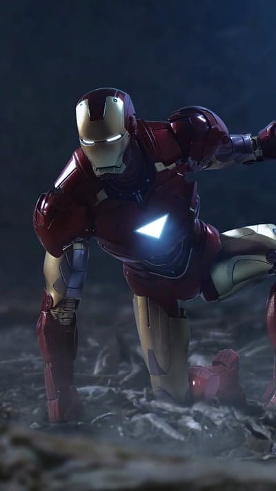 Iron Man in a protective crouch, glowing arc reactor