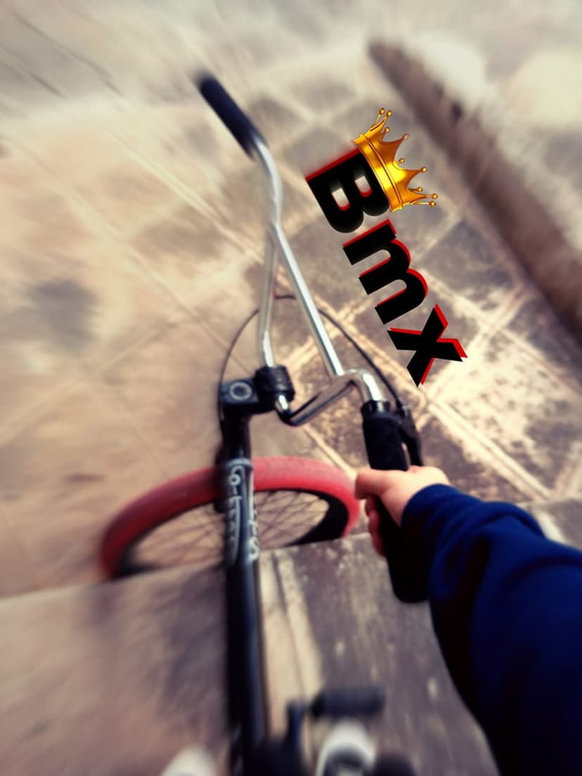 BMX handlebars with a red tire descend grey concrete stairs with a golden crown graphic overlay.