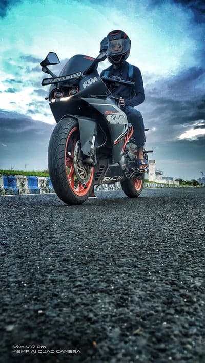 KTM Sportbike Rider Under Dramatic Stormy Sky Wallpaper
