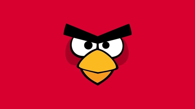 Close-up of Red from Angry Birds with thick black eyebrows and a yellow beak on a red background.
