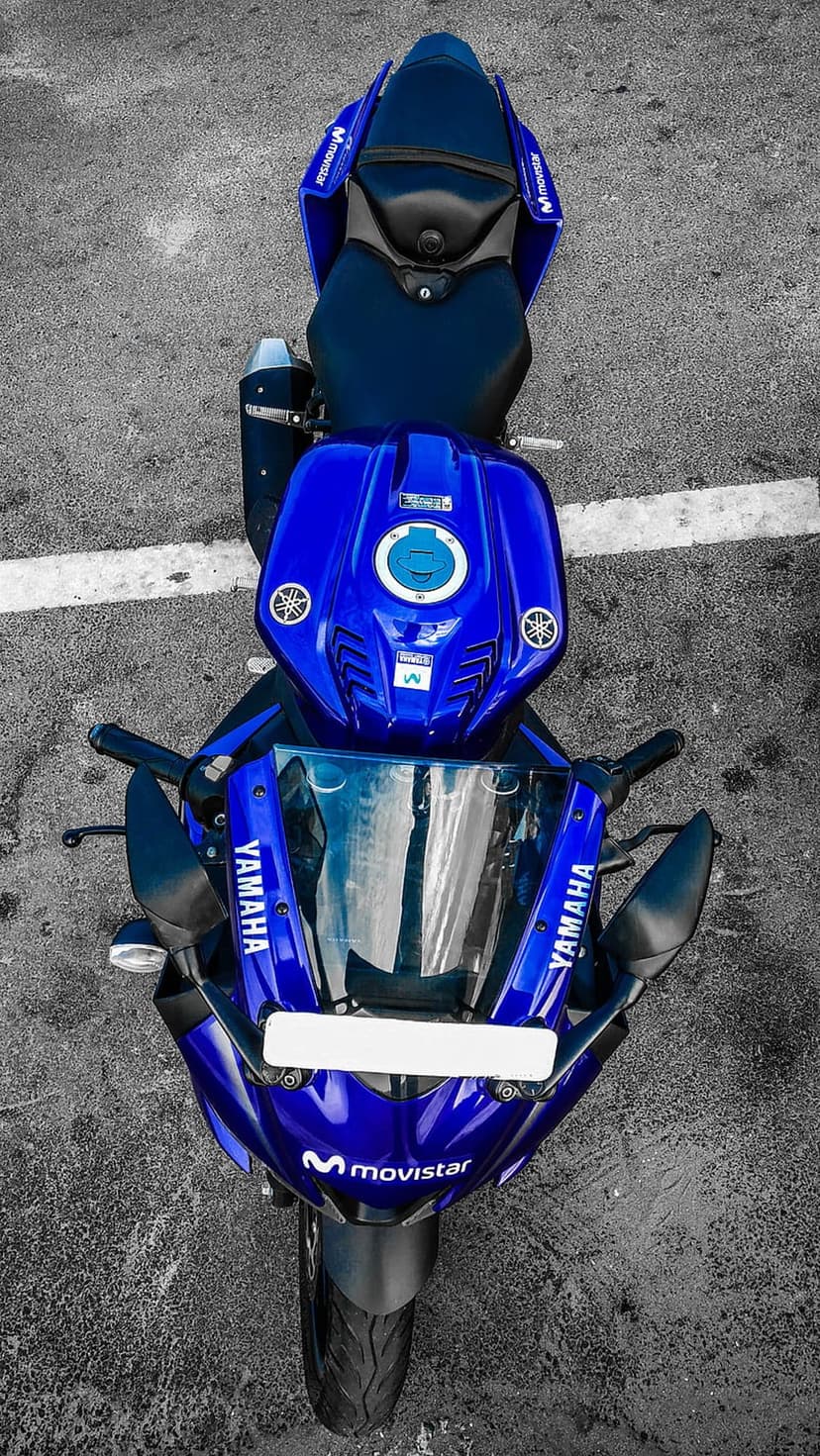 Blue Yamaha motorcycle with Movistar logos parked on a dark, grainy asphalt surface viewed from directly above.