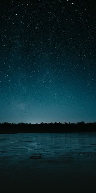 Serene Celestial Blanket Over a Tranquil Lake at Night