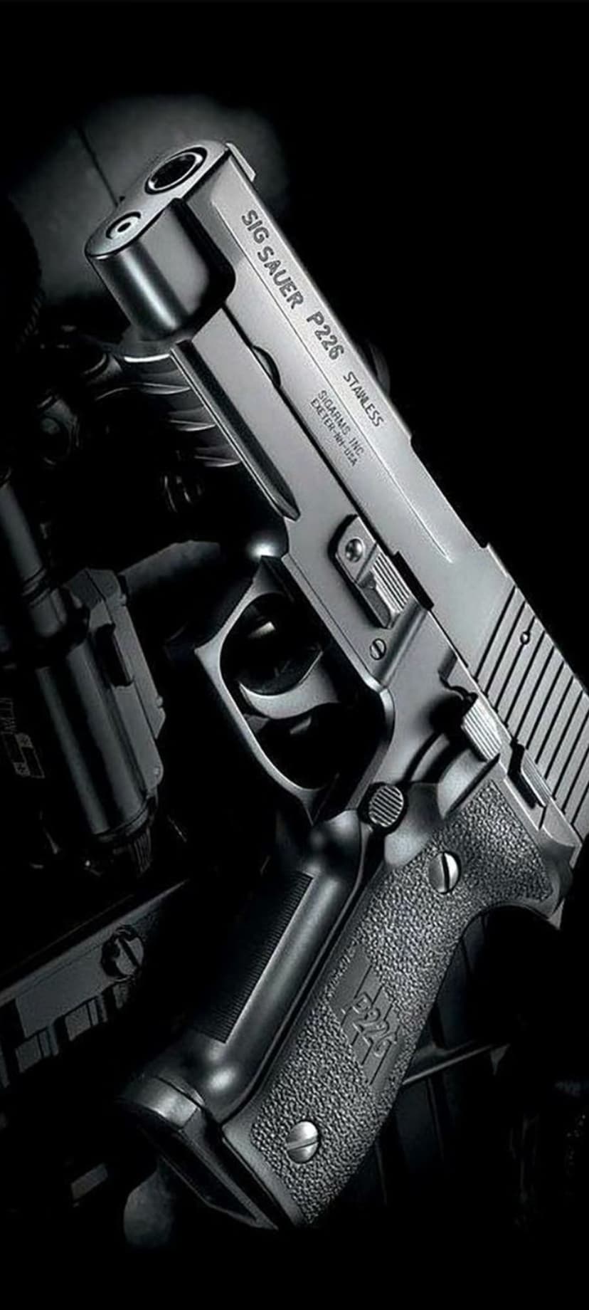 SIG Sauer P226 stainless pistol with textured grips and metallic slide against a dark, dramatic background.