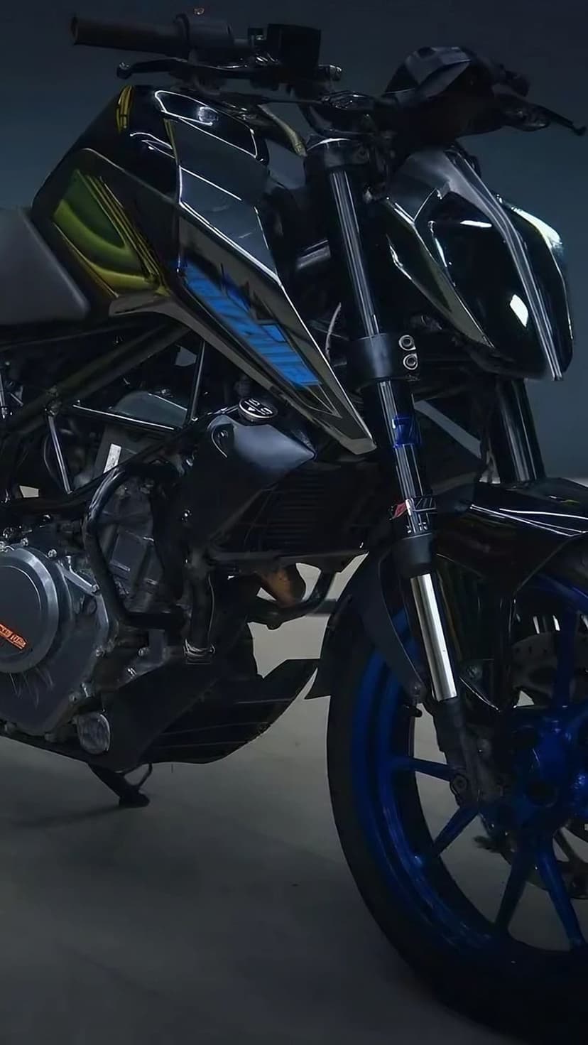 Modern black motorcycle with sharp bodywork, chrome engine parts, and a bright blue front wheel on a dark background.