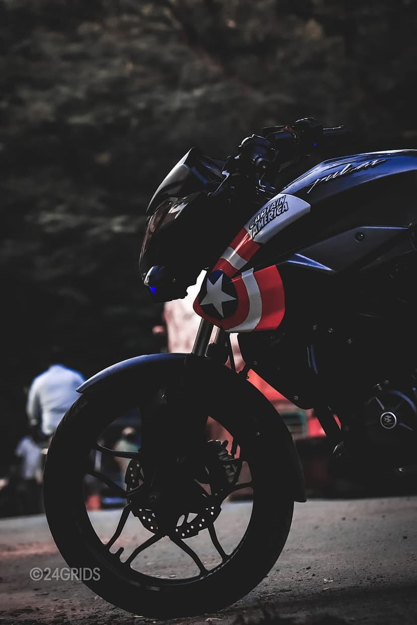 Captain America motorcycle fairing with a white star and red stripes above a chrome disc brake and tire.