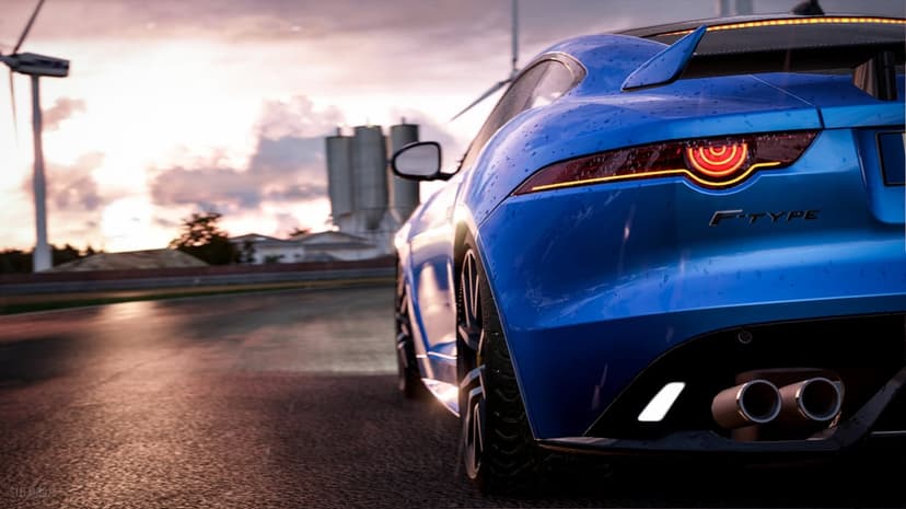 Rear view of a blue Jaguar F-Type on a wet track with glowing circular taillights at sunset.