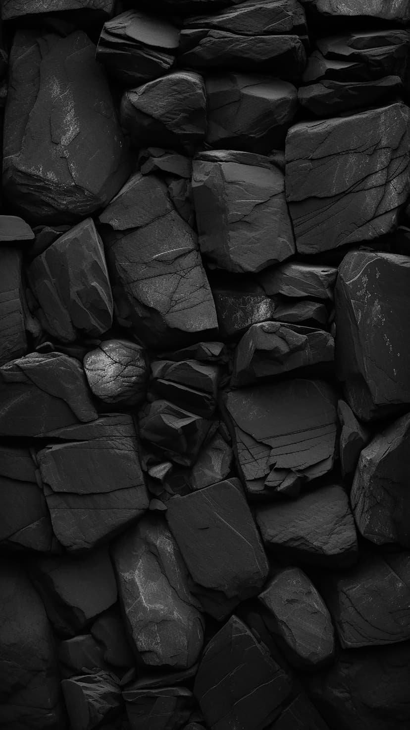 Rough black stone wall with deep cracks, irregular sharp edges, and high-contrast geological surface details.