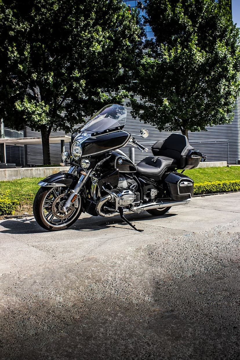 Black BMW R 18 Classic motorcycle with chrome accents parked on concrete near a contemporary silver building.