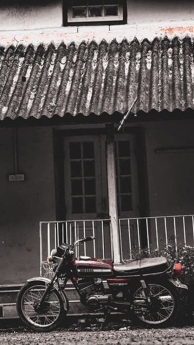 Vintage Yamaha RX100 motorcycle parked by old building