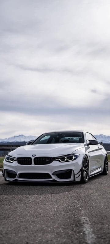 White BMW M4 Coupe on asphalt road with mountains
