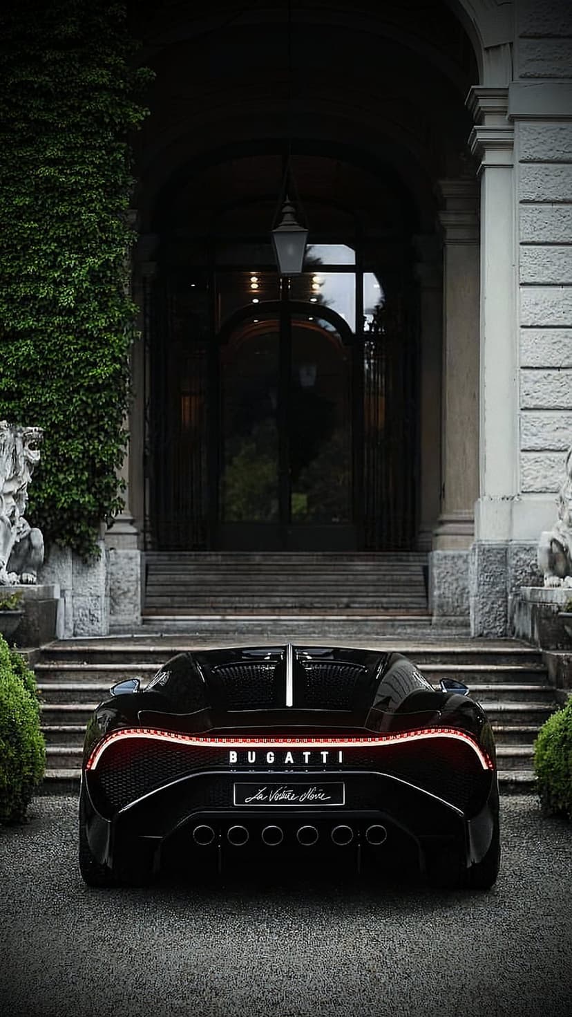 Bugatti Chiron Super Sport 300+ rear parked on gravel before an ivy-clad mansion with stone lions and LED lights.