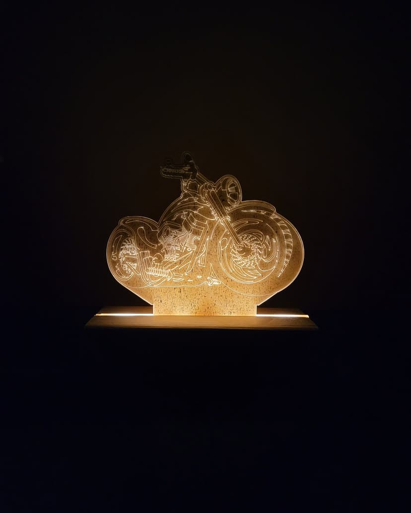 Motorcycle silhouette glowing with orange light showing detailed engine parts and wheels against a dark backdrop.