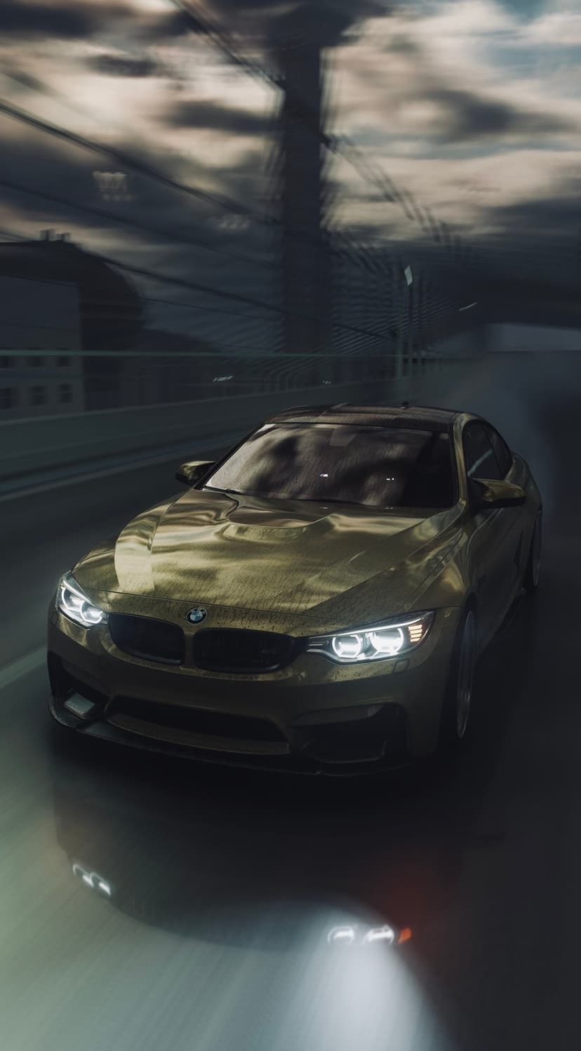 Golden BMW M4 luxury coupe driving on a wet city road at night with glowing headlights and blurred buildings.