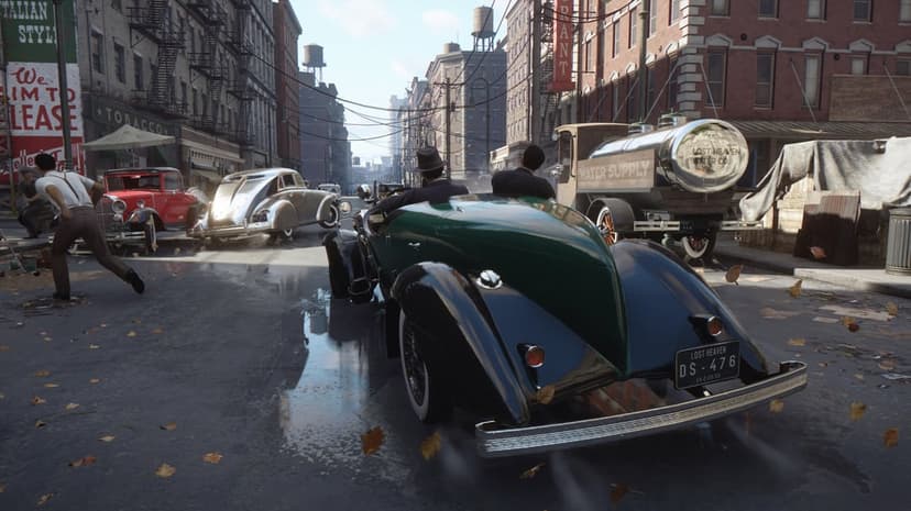 Green vintage car driving through a rainy 1930s city street with brick buildings and fallen autumn leaves.