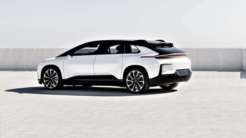 Futuristic white electric SUV with black accents parked on a bright concrete rooftop under a pale sky.