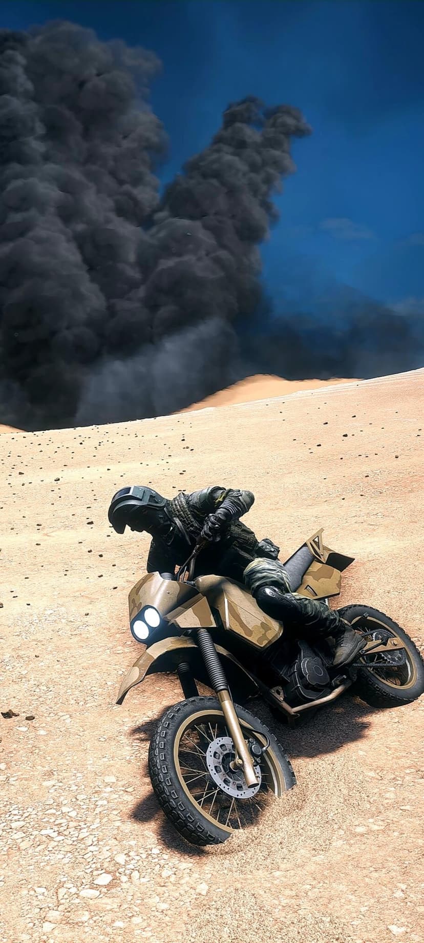 Soldier in full gear riding a dirt bike across sand as a towering black smoke cloud rises into a clear blue sky.