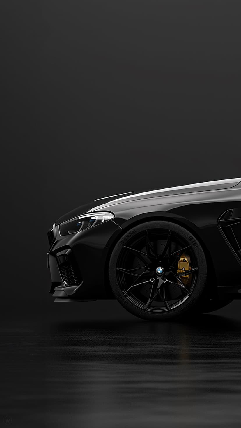 Black BMW M8 Coupe headlight and multi-spoke wheel with gold brake calipers against a dark front bumper.