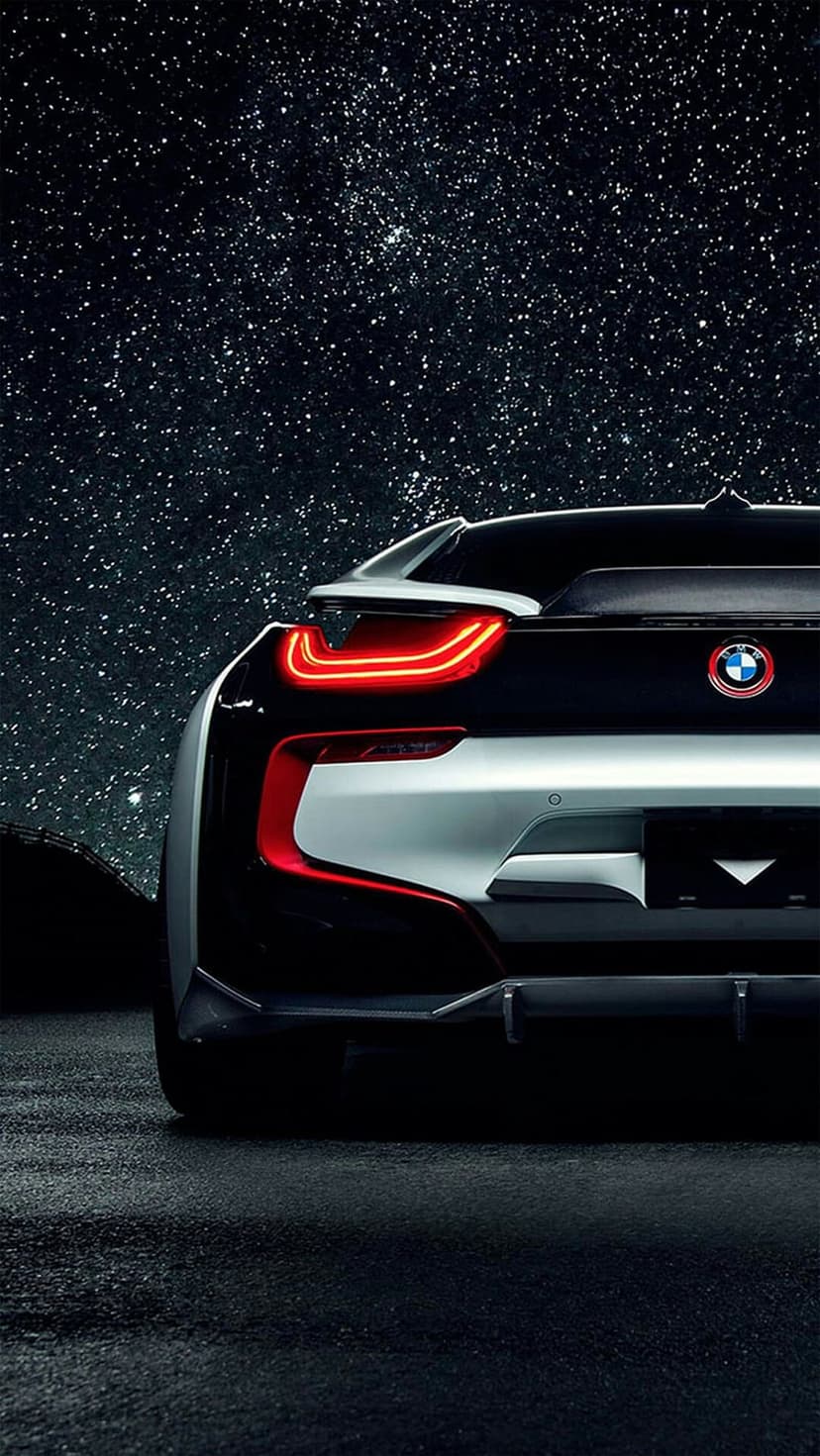 BMW i8 rear view showing glowing red taillights under a dark sky filled with thousands of twinkling white stars.