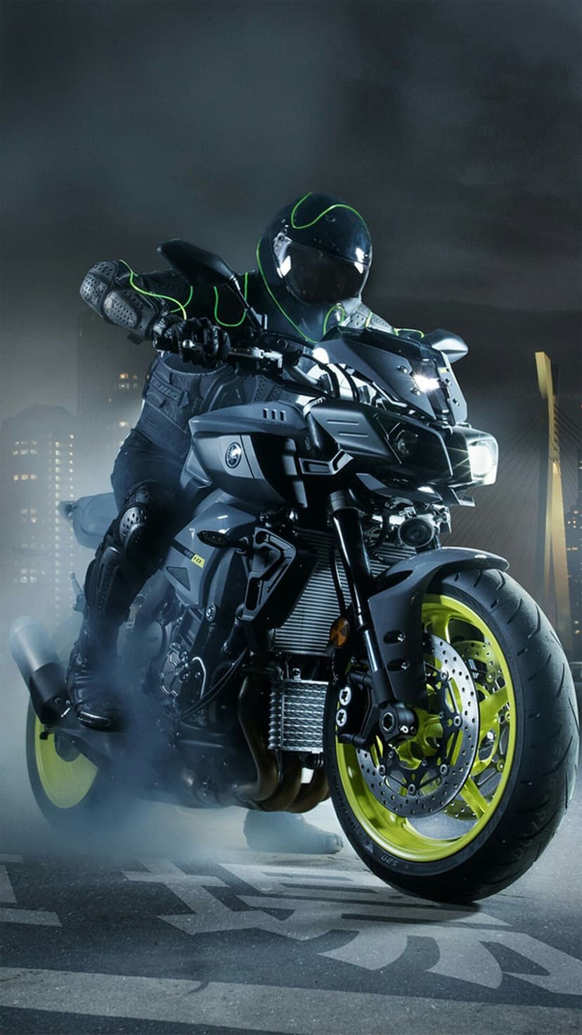 Motorcycle rider wearing a neon green helmet speeds through a smoky city street with glowing yellow wheels.