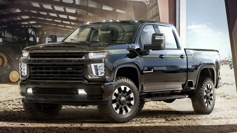 Black Chevrolet Silverado Z71 pickup truck with gold accents parked in a rustic barn with off-road tires.