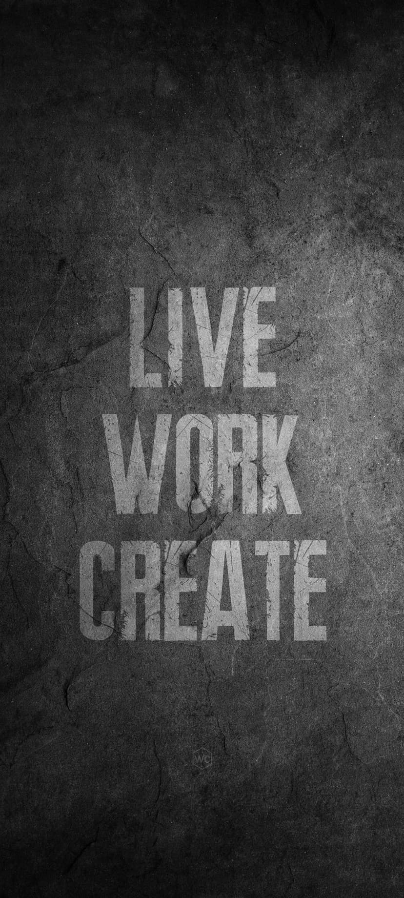 White Live Work Create text in bold font centered on a dark grey gritty stone textured surface background.