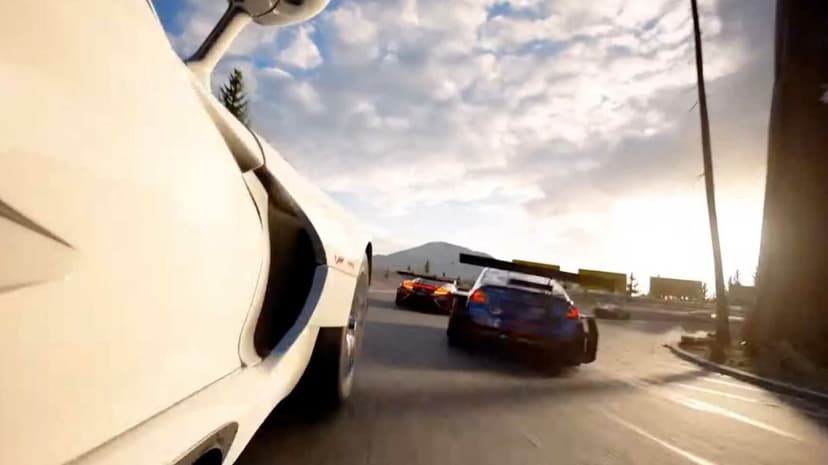White sports car chasing a blue racer on an asphalt track with mountain peaks and trees under a bright cloudy sky.