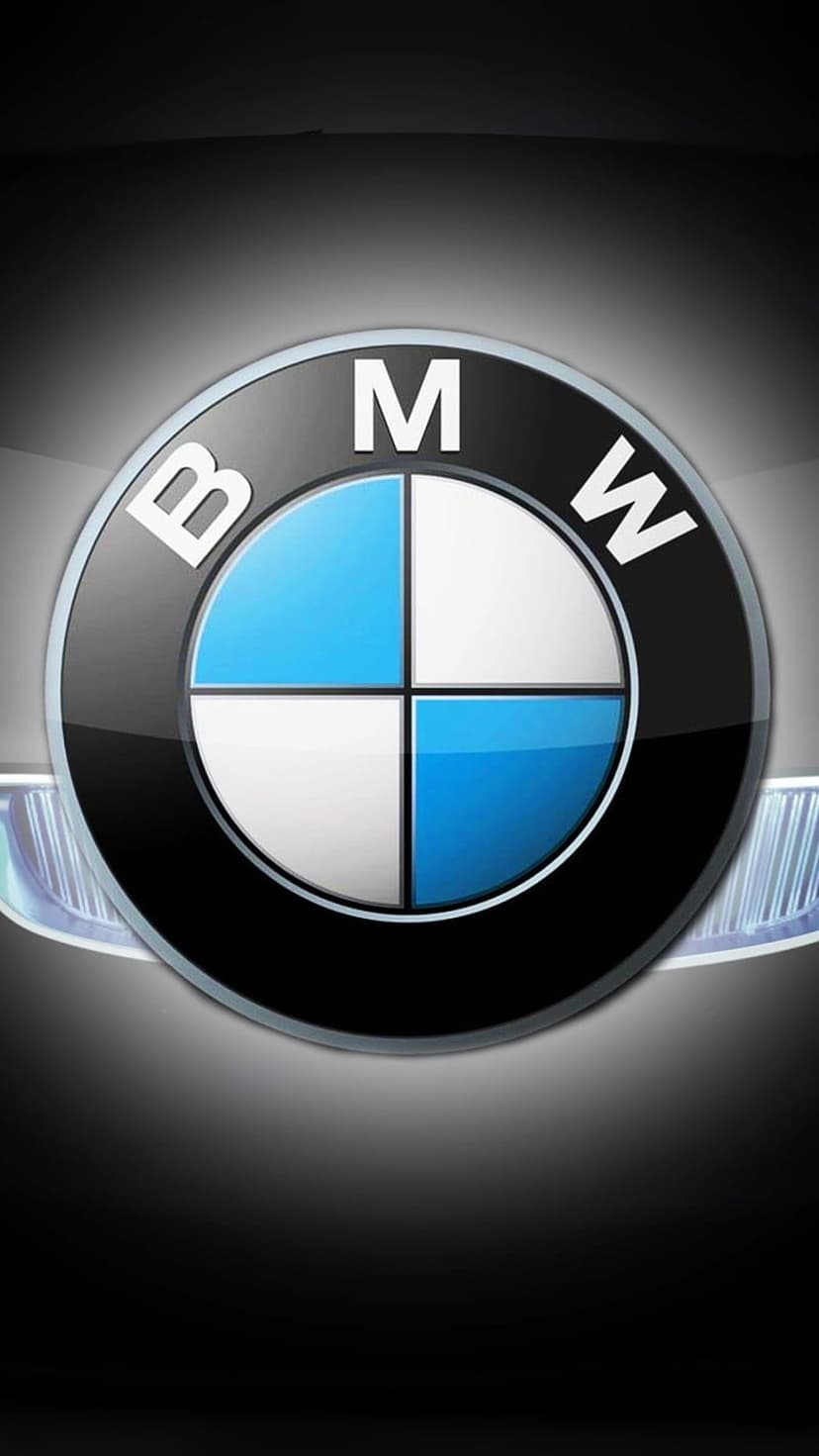BMW roundel logo with blue and white quadrants centered on a black background with abstract chrome car highlights.