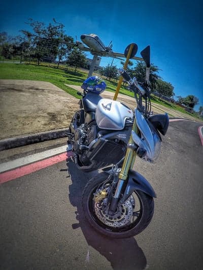 Motorcycle parked next to a vintage airplane display