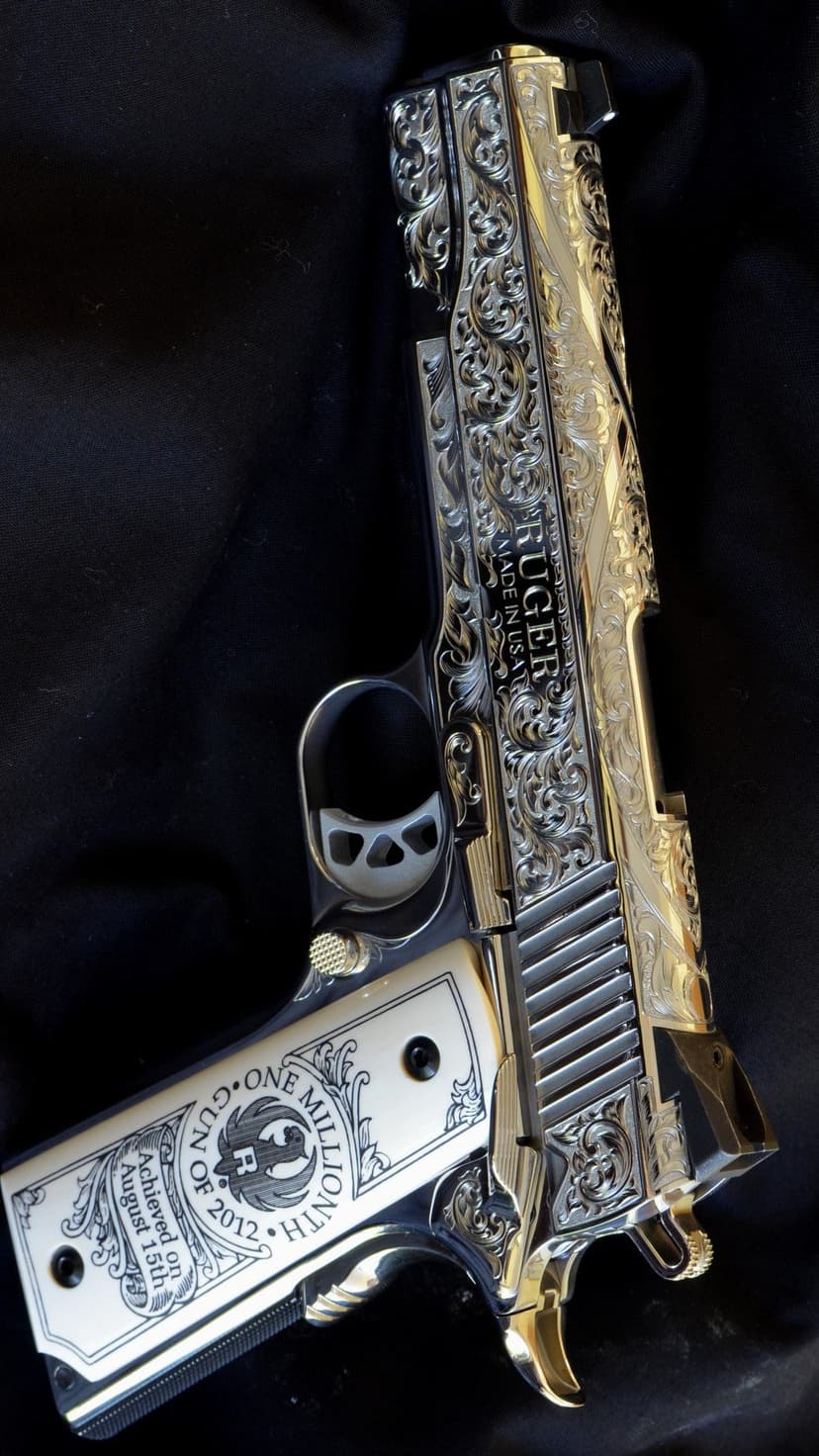 Ornate Ruger pistol with gold and silver scrollwork engravings resting on a dark black fabric background.