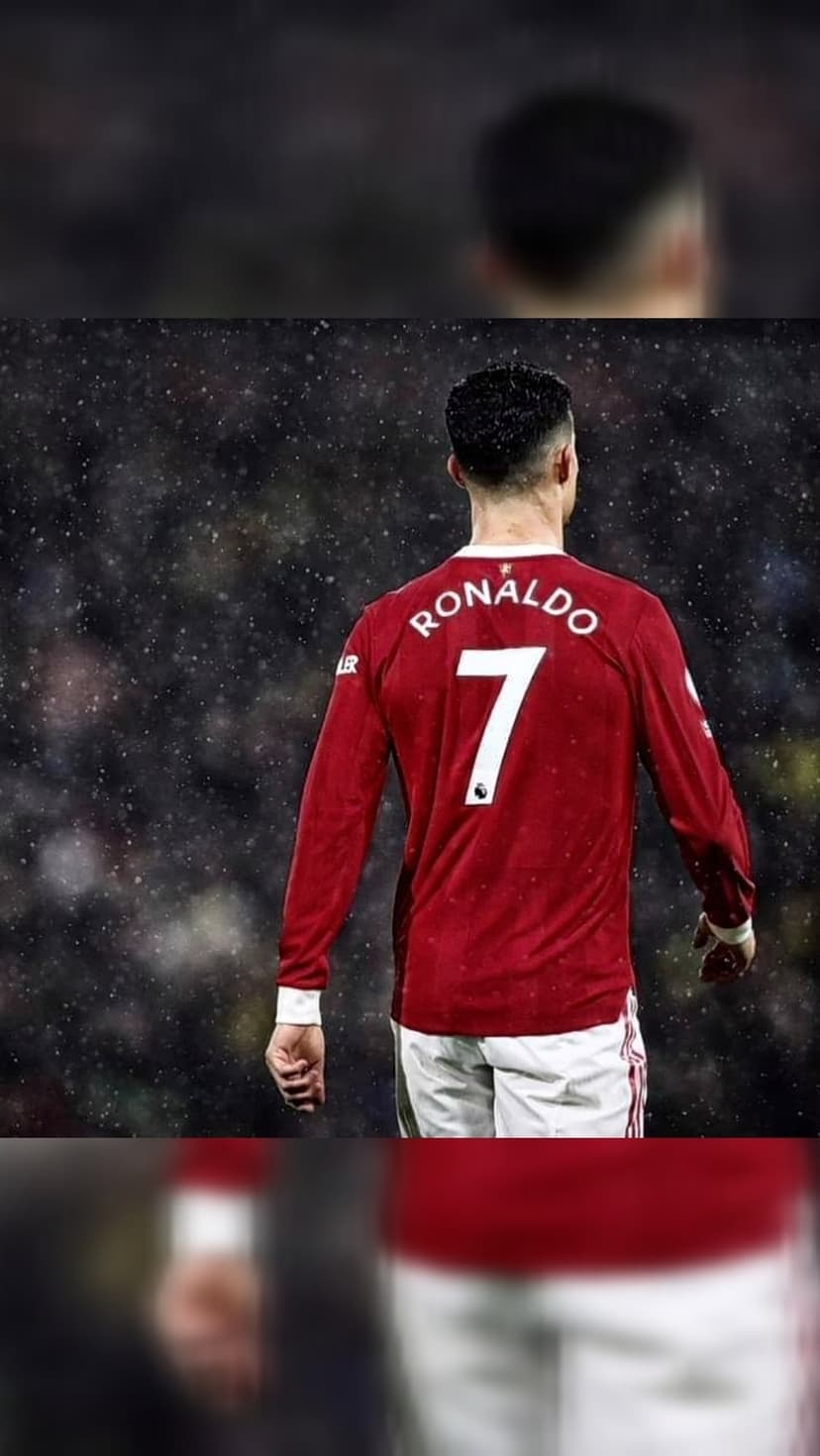Cristiano Ronaldo from behind in a red number 7 jersey with white particles falling on a dark stadium background.