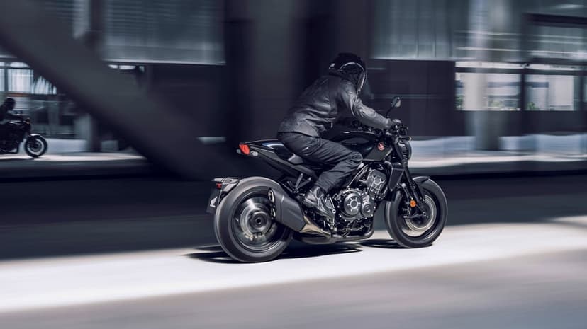 Black Honda motorcycle speeding through a concrete urban tunnel with cinematic motion blur and rider in gear.