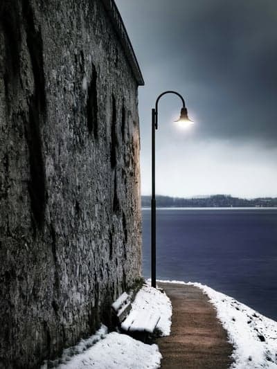 Snowy Coastal Path With Glowing Lamp Phone Wallpaper