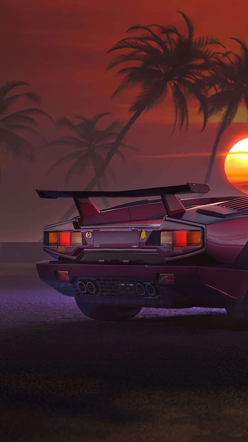Red sports car rear with a large spoiler parked on a beach under orange sunset skies and palm tree silhouettes.