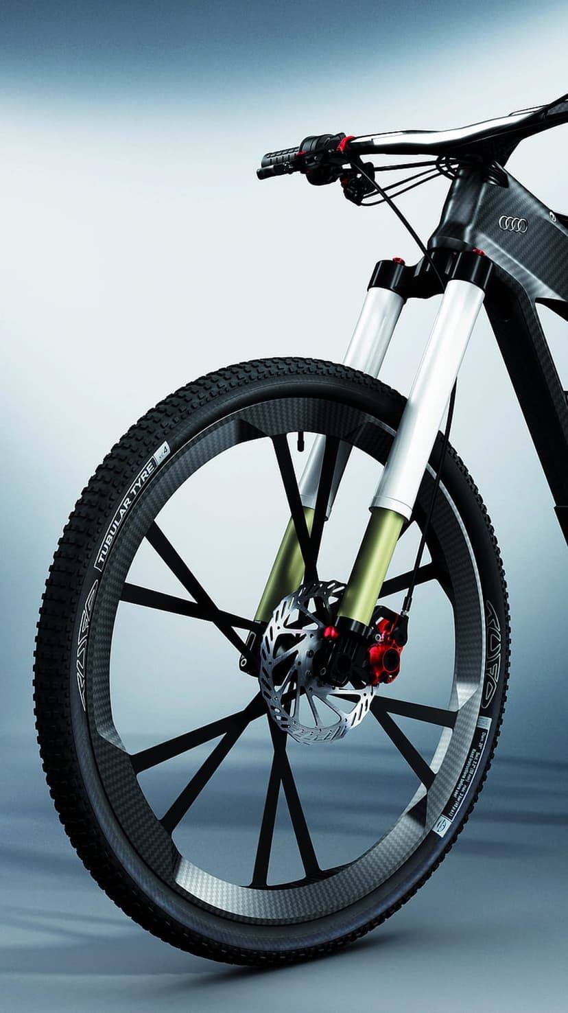 Audi carbon fiber mountain bike featuring red disc brakes, suspension forks, and the four-ring logo on the frame.