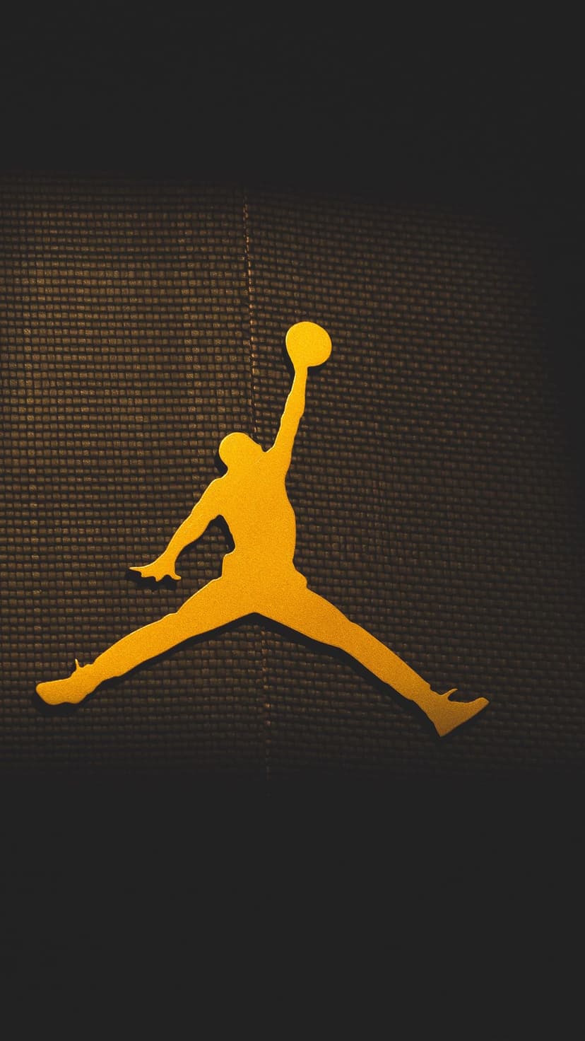 Jumpman logo in metallic gold centered on a dark charcoal textured background with a vertical mobile orientation.