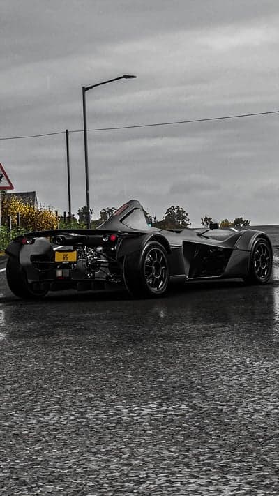 Rainy day with a black sports car on wet road