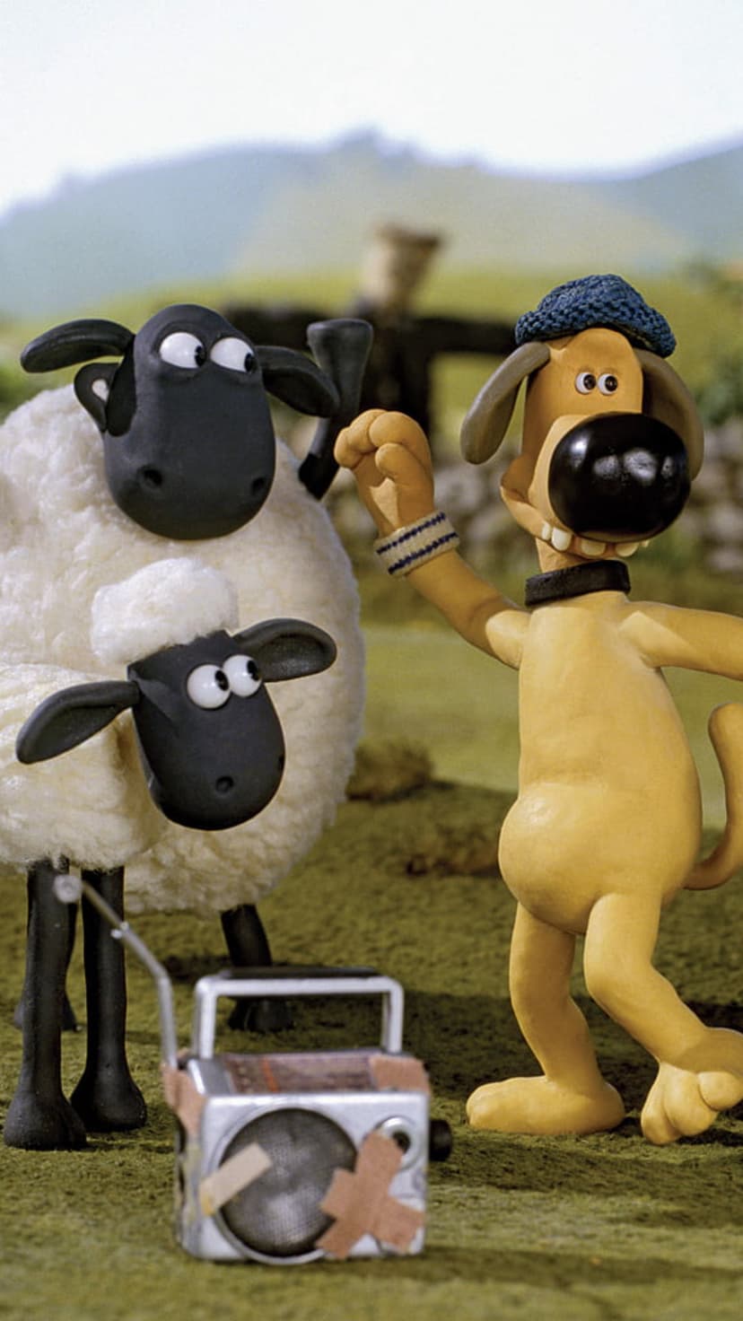 Shaun the Sheep and Bitzer the dog stand in a green field next to a silver radio with bandages on the grass.