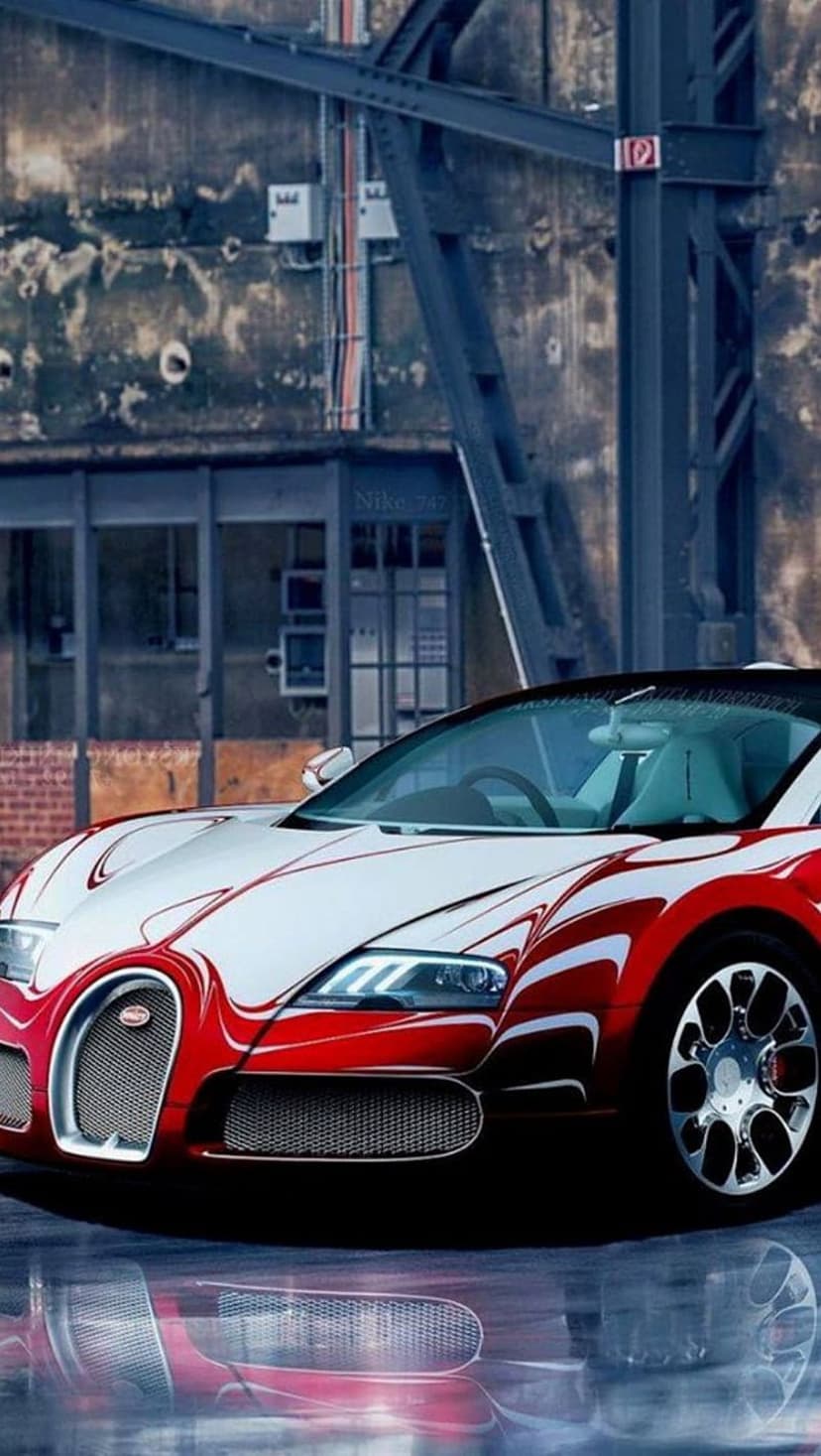 Red and white Bugatti Veyron reflects on a wet industrial floor in a low-angle vertical supercar photograph.