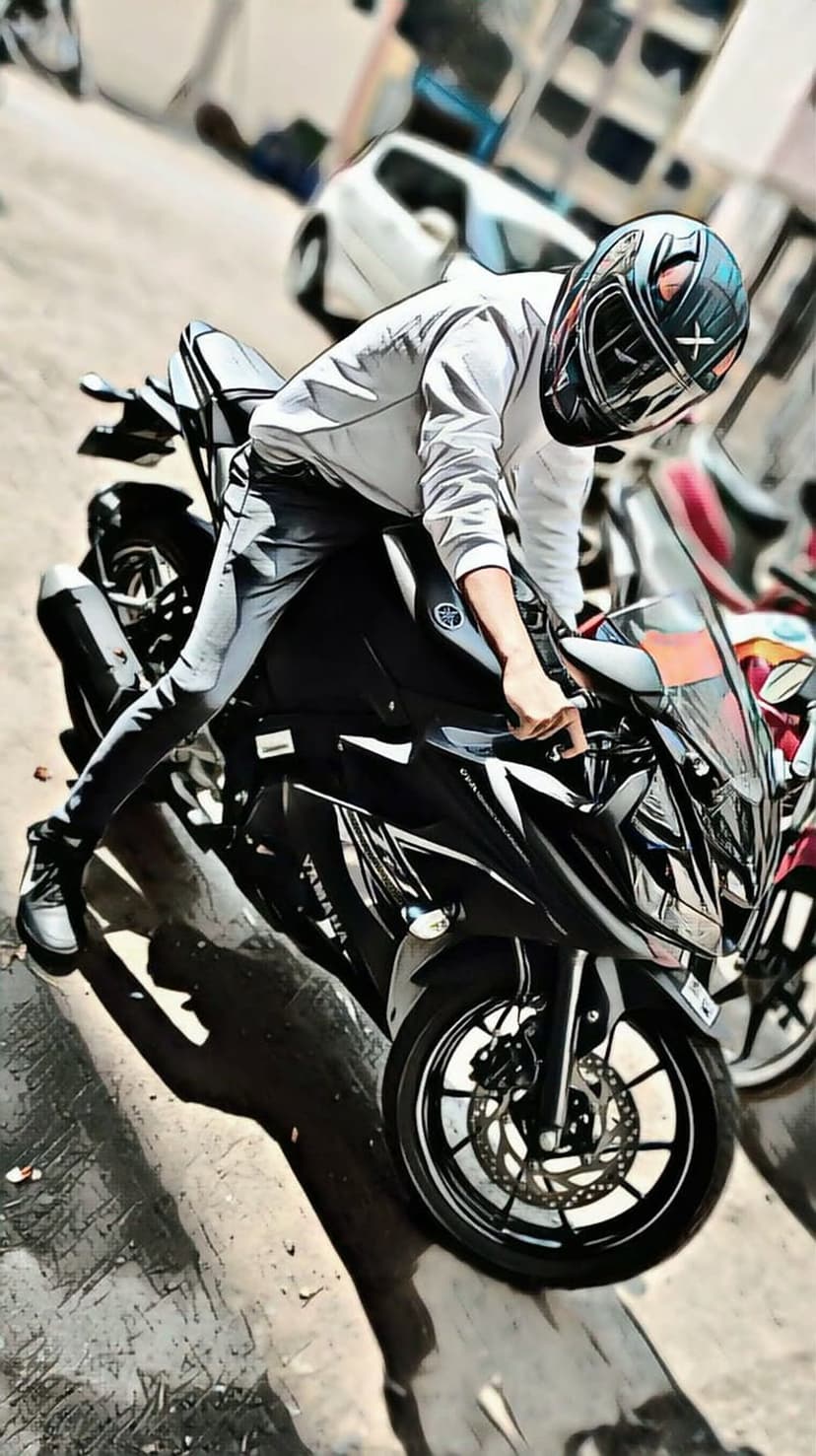 Biker in a black helmet poses on a Yamaha sportbike with a blurred background showing speed and motion.