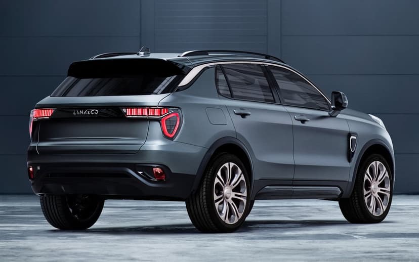 Rear view of a matte grey Lynk & Co SUV with glowing red LED taillights in a dark studio.