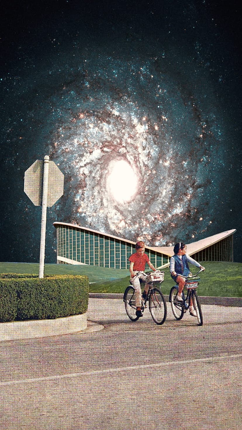 Two children on bicycles ride down a street with a retro building and a massive swirling galaxy in the sky.